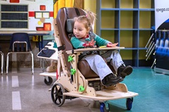 a young child in a custom mobility vehicle