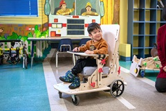 a young child in a custom mobility vehicle