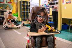 a young child in a custom mobility vehicle