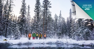 Alison Thompson and her team stand in front of a large pond in a treed backdrop.